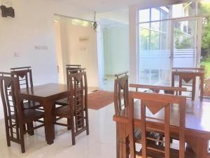 a dining room with a wooden table and chairs at Heriance Anuradhapura in Tammannewa