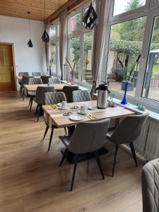 a dining room with tables and chairs and windows at Pension Genz in Bad Karlshafen