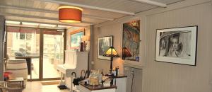a living room with a table and some pictures on the wall at Hotel Montana in De Panne