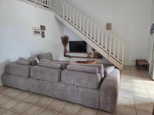 a living room with a couch and a staircase at kaz Lé pa si Ô in La Rivière +25 photos