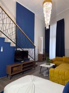a living room with a couch and a tv at Andor Luxury Hotel & Duplex in Durrës