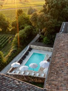 an aerial view of a swimming pool with umbrellas on a house at Demeures & Château - Fleur de Roques - Puisseguin Saint Emilion in Puisseguin