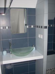 een badkamer met een groene wastafel en een spiegel bij Gite entre Terre et Mer in Ploumilliau