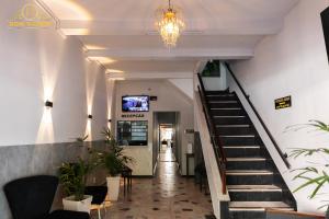 a hallway with stairs and a tv on the wall at Dom Victor Residence Hotel in Goiânia