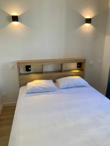 a large white bed with two pillows on it at Hôtel de Paris - Dijon Centre Gare in Dijon
