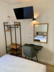 a bedroom with a bed and a mirror and a chair at Hôtel de Paris - Dijon Centre Gare in Dijon