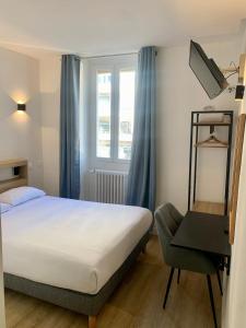 a hotel room with a bed and a chair at Hôtel de Paris - Dijon Centre Gare in Dijon