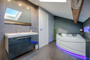 a bathroom with a tub and a sink with purple lights at RG Duplex - Sea View - Palais & Croisette - Luxury Stay by LRA Cannes in Cannes