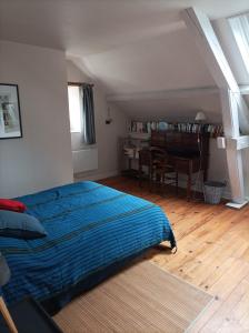 a bedroom with a bed with a blue comforter at chez Zaza in Stigny