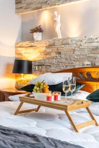 a tray of fruit and wine glasses on a bed at Apartamenty Blisko Centrum in Toruń
