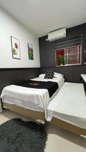 a bedroom with two beds and a window at Flat JK 102 in Juazeiro do Norte