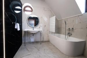 a bathroom with a sink and a tub and a mirror at Hotel Restauracja Browar Lwów w Lublinie in Lublin +36 photos