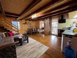 a large living room with a couch and a kitchen at Карпатський котедж Karpatian cottage in Vorokhta