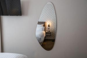 a mirror on a wall in a bedroom with a bed at Hotel Restaurant Au Riesling in Zellenberg +90 photos