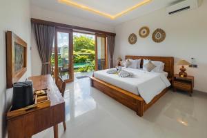 a bedroom with a large bed and a balcony at Damara Ubud in Ubud