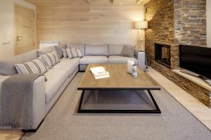 sala de estar con sofá y chimenea en Val de Ruda Luxe 44 by FeelFree Rentals, en Baqueira Beret