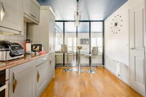 a kitchen with white cabinets and a clock on the wall at Main House in Rotherham