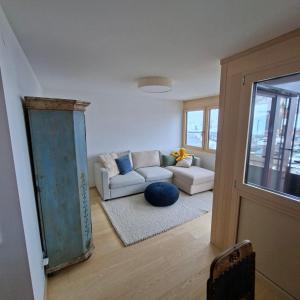 a living room with a couch and a window at Hemmile - Ferienwohnung in Lech in Lech am Arlberg