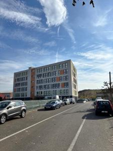 a parking lot with cars parked in front of a building at Sky Escape - Private Parking, Kingsize Bed & More in Cluj-Napoca