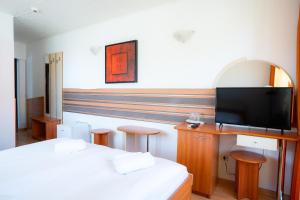 a hotel room with two beds and a flat screen tv at Motel Delorean in Săcele