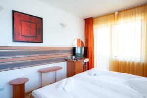 a hotel room with two beds and a television at Motel Delorean in Săcele
