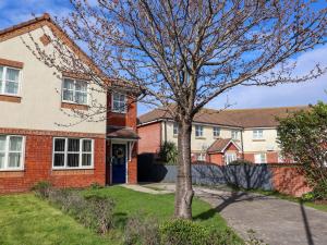 a brick house with a tree in the yard at The Beach Escape in Prestatyn