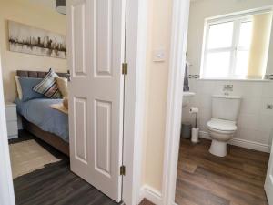 a bathroom with a toilet and a bed with a window at The Beach Escape in Prestatyn +28 photos