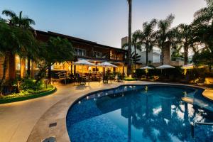 a swimming pool in front of a hotel at Pousada Alcatrazes in Juquei