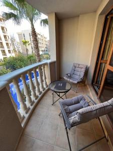 a balcony with a table and two chairs and a table at Cascadas, Studio apartment with a pool view in Sunny Beach