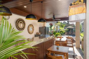 a restaurant with a counter and tables and chairs at Damara Ubud in Ubud
