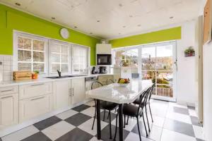 a kitchen with a table and chairs and green walls at La Villa des Hauts Chênes in Bouillon