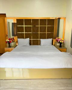 a bedroom with a large bed with a large headboard at Private Rooms In Riverstone in Karjat
