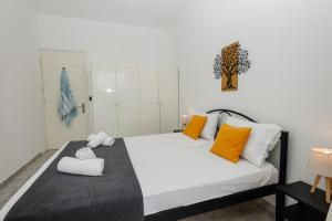 a bedroom with a large bed with orange and white pillows at Ionian Luxury Apartments in Perama