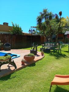 a yard with benches and a pool and a fence at Posada del Baradero in Baradero