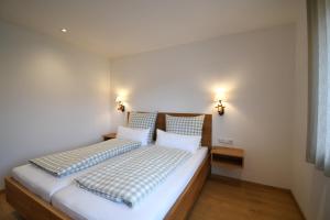 a bedroom with a large white bed with two pillows at Alm Annerl - Neue Ferienwohnungen in Obermaiselstein in Obermaiselstein