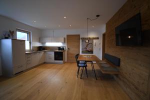 a kitchen and dining room with a table and a television at Alm Annerl - Neue Ferienwohnungen in Obermaiselstein in Obermaiselstein