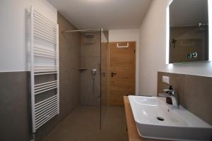 a bathroom with a sink and a shower at Alm Annerl - Neue Ferienwohnungen in Obermaiselstein in Obermaiselstein +8 photos