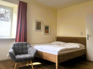 a bedroom with a bed and a chair at Haus Pleterski in Obervellach