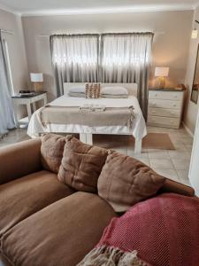 a living room with a bed and a couch at 36 Mount Road Guesthouse and Self Catering in Port Elizabeth +45 photos