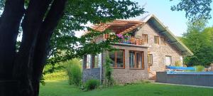 a stone house with a balcony on top of it at Darázshegyi Panzió és Faházak - Panzió épület in Mátraszentimre