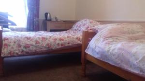 a bedroom with two beds and a dresser with a window at Bannockburn Inn in Helmsdale