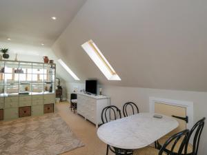 a room with a table and chairs and a cabinet at The Hideaway Loft in Chippenham