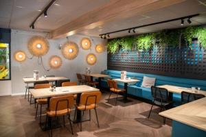 a restaurant with tables and chairs in a room at Mobilehome Super Mercure 2 Bedrooms Comfort Camping Scheldeoord in Baarland