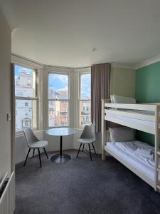a bedroom with a bunk bed and a table and chairs at The Brighton Hotel Seafront in Brighton & Hove