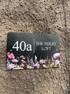 a sign on a wall with flowers on it at The Ferry Loft Montrose in Montrose