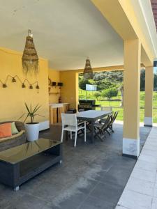a patio with a table and chairs and a couch at Quinta da Corticeira in Elvas
