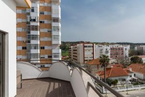 a balcony with a view of a city at WOT Costa da Caparica Soul in Costa da Caparica