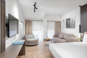 a bedroom with a bed and a living room at Athenian Heart Suites in Athens