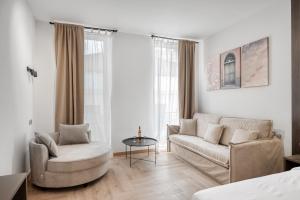 a living room with a couch and a chair and a table at Athenian Heart Suites in Athens
