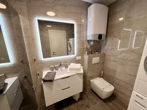 a bathroom with a sink and a toilet and a mirror at Seaview Residence Krk 2 Bedrooms 2 Bathrooms Free Parking in Krk